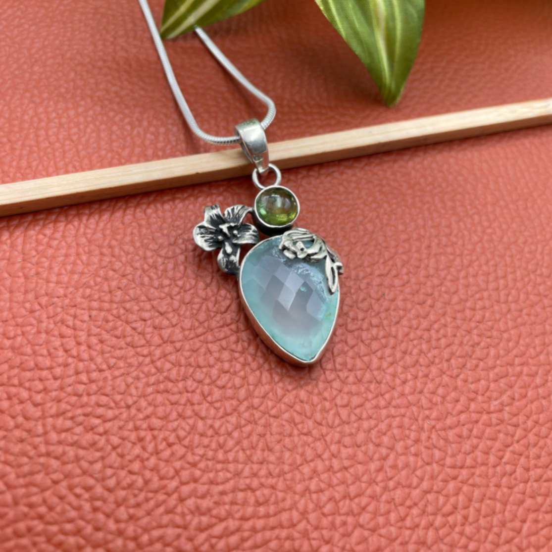 Silver floral pendant with drop shape aqua blue stone